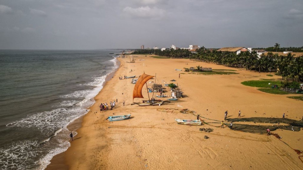 Wide sandy beach with fishing boats, Poruthota